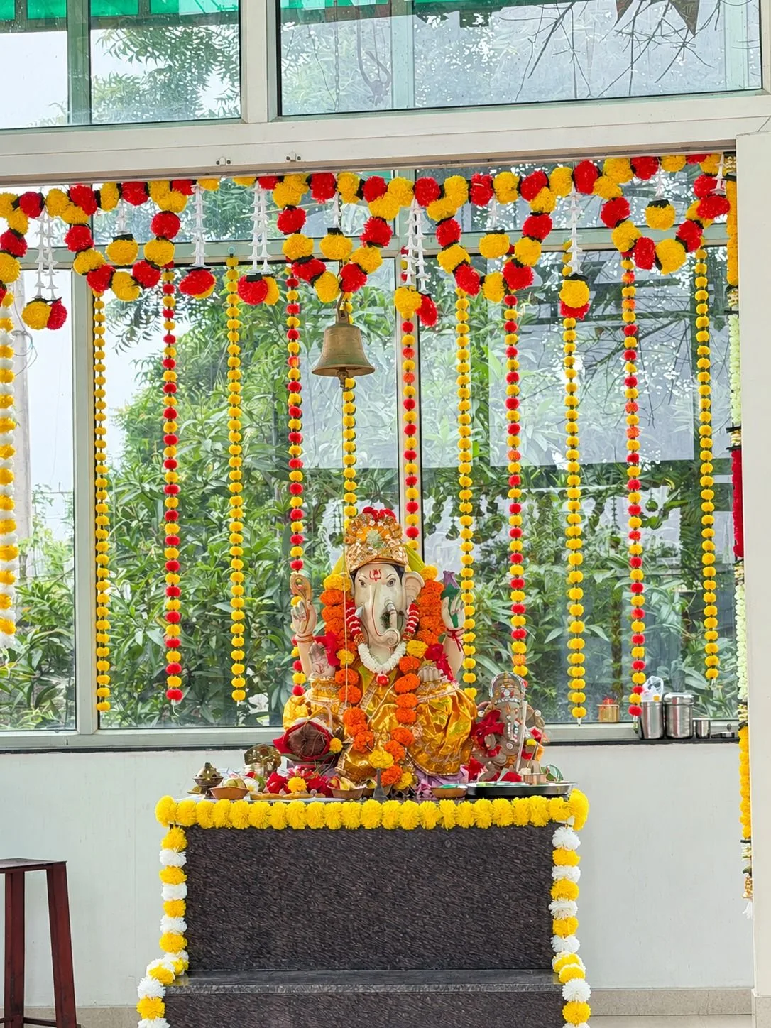 A Ganesh idol decorated with marigold garlands at the ReBAT facility for Ganesh Chaturthi.